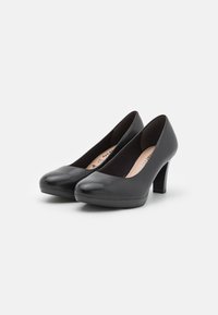 Escarpins noirs en cuir, à talons hauts, avec des bouts arrondis et une finition lisse. Ils possèdent un talon robuste et une semelle intérieure rembourrée pour un meilleur soutien.