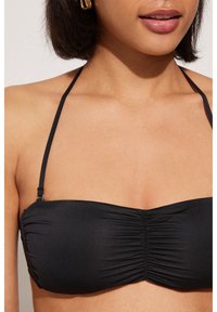 Czarny biustonosz bikini z marszczonym przodem, regulowanymi ramiączkami i minimalistycznym designem. Gładka tekstura i bezszwowe wykończenie.