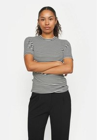 Zwart-wit gestreepte korte mouwen t-shirt met een ronde halslijn en een getailleerd ontwerp, gecombineerd met zwarte broeken.