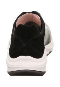 Czarny i szary sneaker z zaokrąglonym noskiem, zamszowymi akcentami z tyłu i wyściełanym różowym wnętrzem. Charakteryzuje się masywną białą podeszwą.