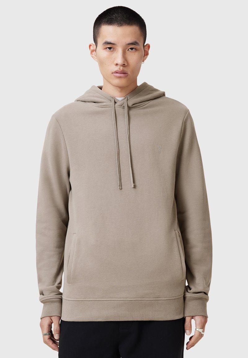 Beige hoodie met een kangoeroezak, ribgebreide manchetten en zoom. Heeft een subtiele geborduurde logo op de borst. Soepele textuur.