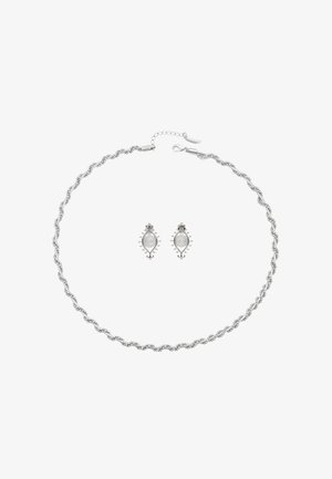 Zilveren ketting met een gedraaide vorm en kralenaccenten, gecombineerd met bijpassende ovale oorbellen met een getextureerd oppervlak en decoratieve randen.