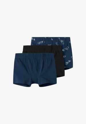 Drei Paare Jungen-Boxershorts: eine schwarze, eine einfarbige marineblaue und eine marineblaue mit einem weißen Motiv von Sicherheitsnadeln. Aus Baumwollmaterial.