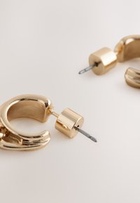 Gold-tone hoop earrings with a polished finish, featuring a rounded design and post-back closure for secure wear.