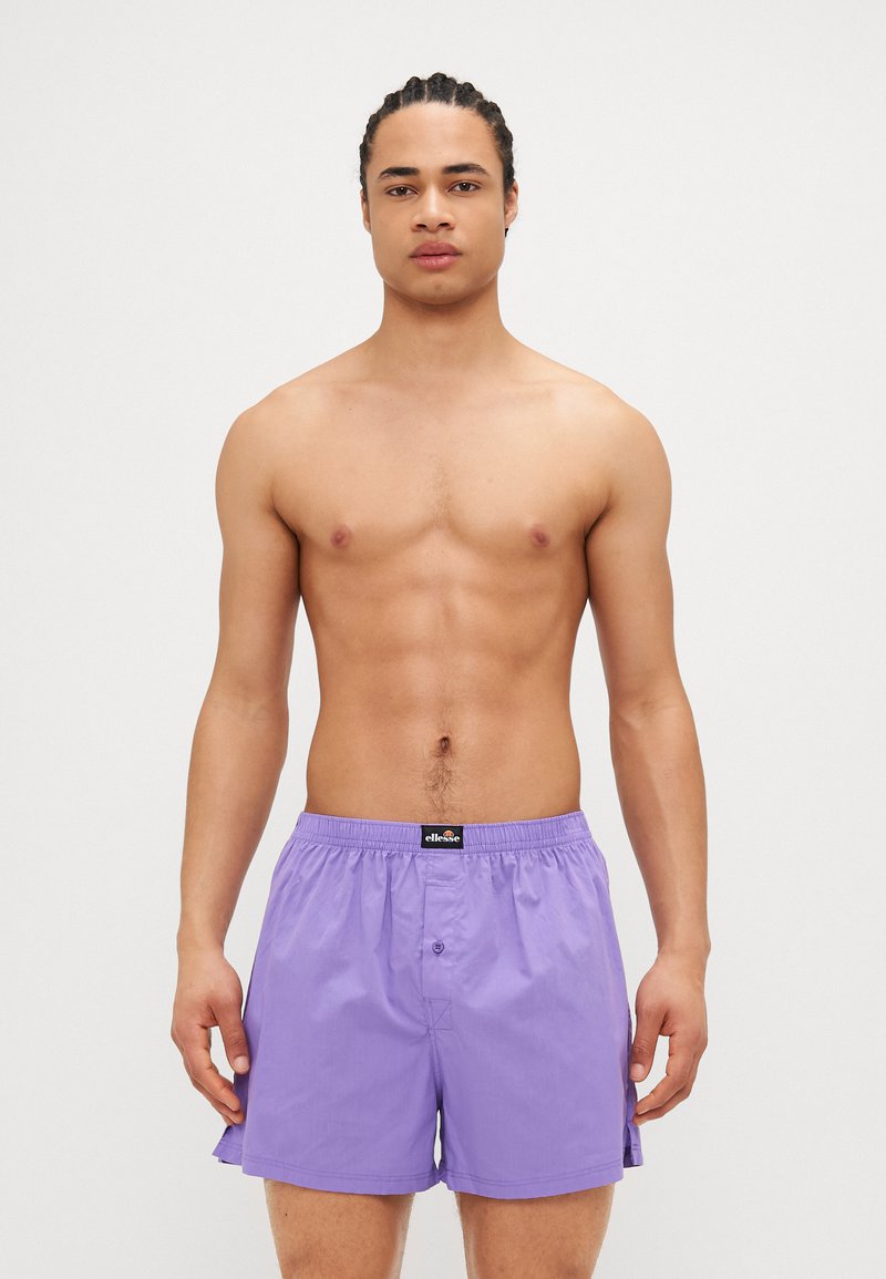 Μωβ μαγιό με ελαστική μέση, κούμπωμα μπροστά και πλαινές σχισμές για αυξημένη κινητικότητα. Κατασκευασμένο από ελαφρύ υλικό.