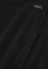 Zwarte corduroy stof met een verticale ribbelstructuur, met een subtiel grijs dierenlogo in het bovenste gedeelte.