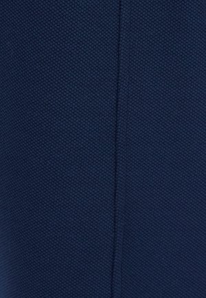 Close-up of navy blue fabric with a small textured honeycomb pattern and a vertical seam running down the center.