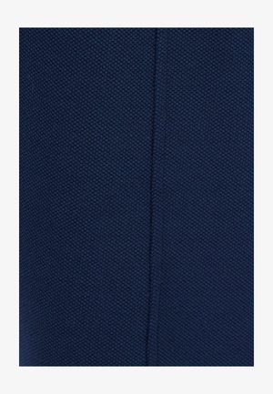 Close-up van marineblauwe stof met een klein, gestructureerd honingraatpatroon en een verticale naad die in het midden naar beneden loopt.