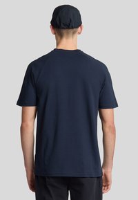 T-shirt blu navy a maniche corte con vestibilità classica, realizzato in tessuto morbido, dotato di collo rotondo e orlo pulito. La vista posteriore non mostra dettagli aggiuntivi.
