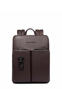 Mochila de cuero marrón con una textura suave, que cuenta con dos bolsillos frontales con cremallera, un asa superior y tirantes ajustables.