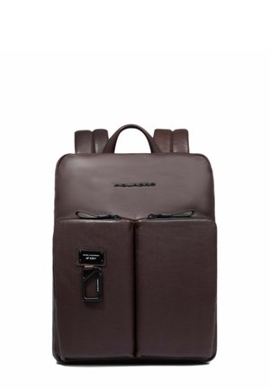 Mochila de cuero marrón con una textura suave, que cuenta con dos bolsillos frontales con cremallera, un asa superior y tirantes ajustables.