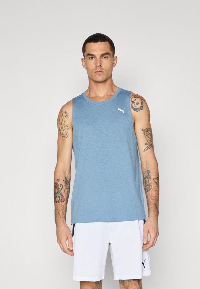 Blå bomulds tanktop med rund halsudskæring og et hvidt logo på brystet, parret med hvide shorts. Velegnet til sportstøj.