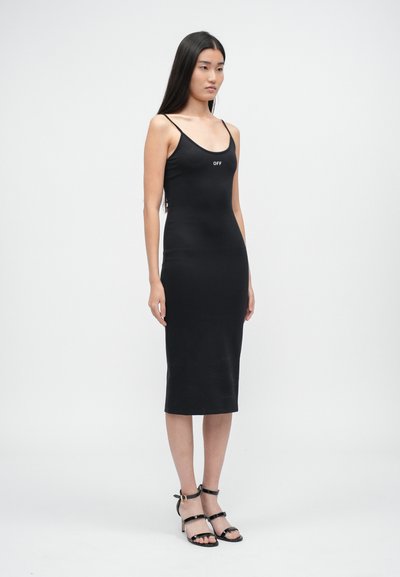 Rochie midi neagră, ajustată, cu bretele subțiri și logo-ul alb "OFF" pe piept. Textură fină, până la genunchi, purtată cu tocuri negre cu bretele.