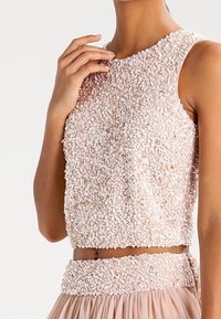 Beadbesetztes, kurzes Top in zartem Rosa, mit rundem Ausschnitt, ärmellosem Design und verziertem Textur mit Pailletten und einem passenden Bund.