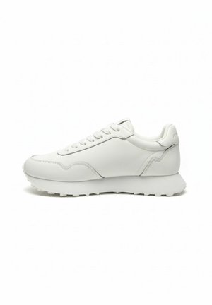 Witte lage sneaker met veters aan de voorkant, een getextureerde zool en subtiele stikseldetails langs de zijkanten en hiel.