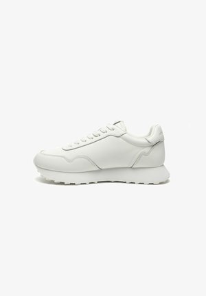 Witte lage sneaker met veters aan de voorkant, een getextureerde zool en subtiele stikseldetails langs de zijkanten en hiel.