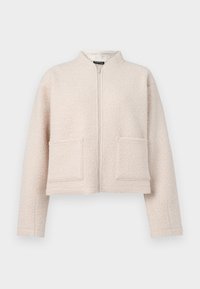 Ljusbeige kort jacka i texturerat tyg, med framdragkedja och två stora påsydda fickor. Ståkrage.