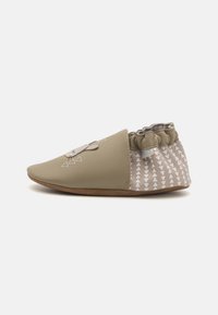Grønn lær slip-on sko med grå mønstret hæl og elastisk topp. Har trekantede design og en sydd aksent. Flat skinnsåle.