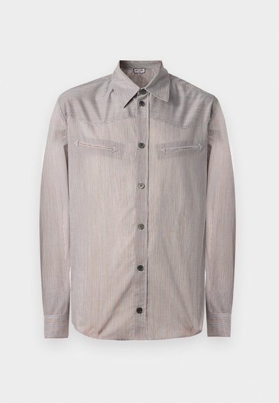 Ribadeelne nupp-paita heledates värvides, klassikalise krae, kahe rinna tasku ja pikkade varrukatega. Sujuv tekstuur vähese läikega.