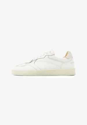 White low-top sneaker with lace-up front, stitched leather upper, padded collar, and beige textured rubber sole.