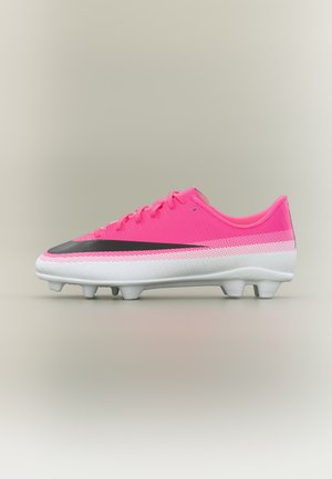 Chaussure de football rose vif avec semelle blanche et logo swoosh noir, vue de côté sur un fond neutre.