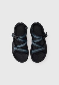 Sandálias pretas de dedo aberto com tiras cruzadas ajustáveis azuis e fivelas de liberação rápida em fundo branco.