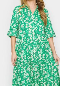 Grön blommig klänning med krage, trekvartsärmar och ett lager-på-lager-design med en lös passform och mjuk textur.