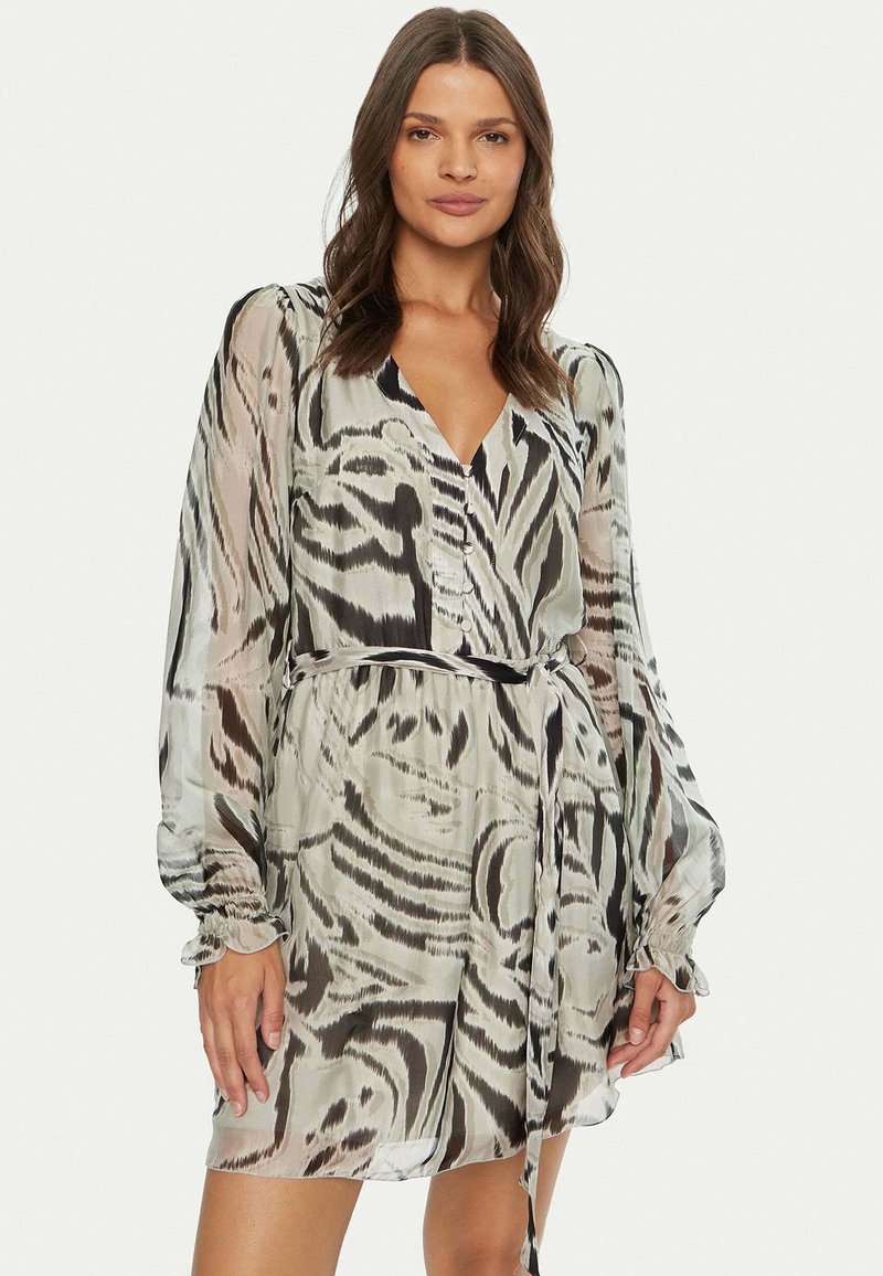 Abito corto semitrasparente con scollatura a V, motivo astratto in bianco e nero, maniche lunghe, vita profilata e cintura. Texture liscia.