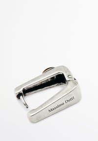 Cappuccio metallico argento con un design curvo, dotato di un piccolo becco appuntito. Inciso con "Massimo Dutti" sul lato. Texture liscia.