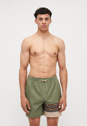 Groene zwemshorts met een elastische taille, beige accenten en een gestreepte zijkant met zwarte en oranje ontwerpen. Lichtgewicht stof.