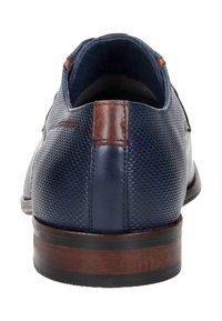 Marineblauwe lederen schoen met een gestructureerde bovenkant, bruine leren accenten en een bruine houten hak. Afgeronde neus met minimale stikseldetails.