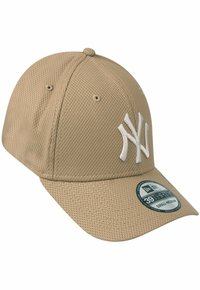 Beige baseball cap made of textured fabric, featuring a white embroidered logo and a curved brim. Includes a size sticker on the side.