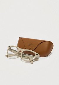 Ray-Ban briller med en lys beige plastisk ramme har runde linser, sammen med en brun læderetui med trykknaplukning.