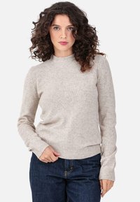 Light grey knit sweater with a ribbed crew neck and long sleeves. Features a soft texture and slightly fitted design, paired with dark denim.