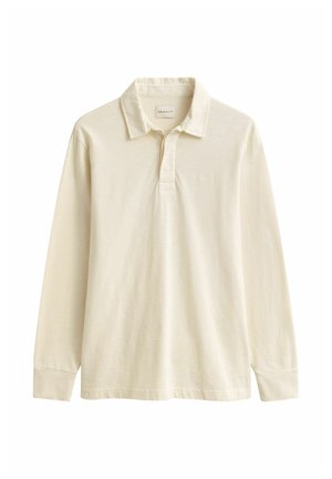 Polo à manches longues beige avec col et patte de boutonnage, en tissu doux, présenté sur fond blanc.