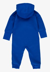 Macacão azul com capuz e mangas compridas, feito de um tecido macio. Apresenta punhos e aberturas nos tornozelos canelados. Sem padrões ou materiais visíveis.
