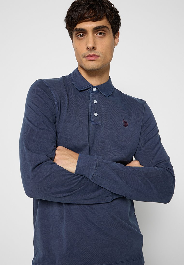 Navyblaues Langarm-Polohemd mit klassischem Kragen, drei Knöpfen und gesticktem Logo auf der linken Brust. Glatte Textur.
