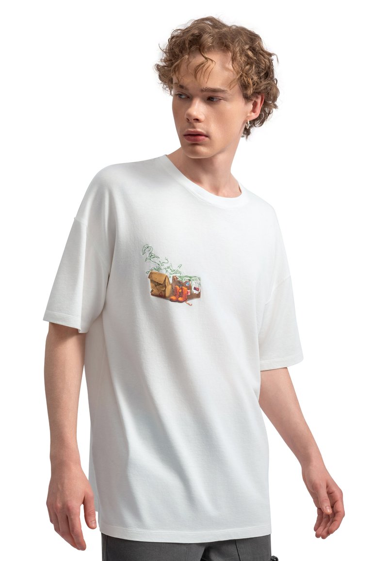 Witte katoenen t-shirt met een kleurraf afbeelding van een tas en fruit op de linker borst. Loose fit met een ronde hals.