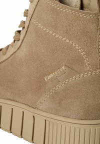 Beige Wildleder-Ankle Boots mit tonal abgestimmter Nähte, runden Schnürsenkeln und einer geriffelten Gummisohle. Akzentuiert mit einem gestickten Logodetail.