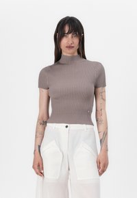 Ribbad kortärmad topp i taupe med hög halsringning och åtsittande silhuett. Har texturerad tyg och subtil kantdetalj.