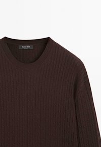 Hnědý pletený svetr s kabelkovým vzorem, kulatým výstřihem a žebrovanými manžetami. Na etiketě je napsáno "Massimo Dutti." Hladká textura a standardní střih.