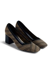 Chaussures à talons blocs rayées noir et or avec un dessus en tissu lisse et un design à bout pointu, présentant une large ouverture et des accents minimalistes.