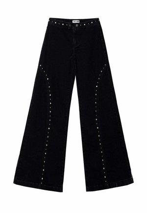 Vaqueros negros de pierna ancha con detalles de tachuelas plateadas a lo largo de las costuras de las piernas y la cintura, con cierre frontal de botón y cremallera.