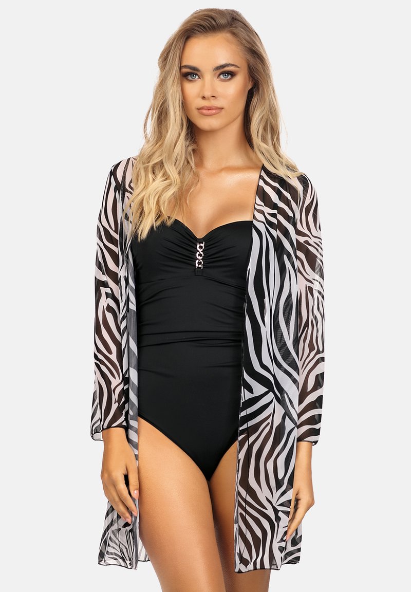 Okrycie wierzchnie w nadruk zebry wykonane z lekkiego, przejrzystego materiału. Posiada długie rękawy i luźny krój, warstwowane na czarnym stroju kąpielowym z ozdobną klamrą.