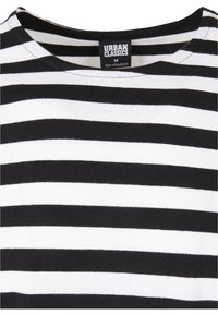 Maglietta a righe bianco e nere con colletto rotondo e maniche corte. Realizzata in morbido cotone, con un'etichetta che riporta "Urban Classics" e la taglia "M."