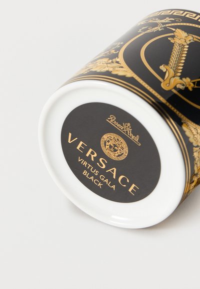 Μαύρη και χρυσή πορσελάνινη κούπα Versace Virtus Gala με περίπλοκα μπαρόκ σχέδια και το λογότυπο της Μέδουσας σε λευκό φόντο.
