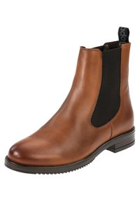 Botín de cuero marrón con paneles laterales elásticos y una pestaña para tirar. Presenta una textura suave, puntera redonda y un tacón bajo apilado.