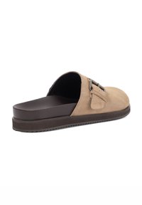 Brown suede slip-on shoe with a rounded toe, a small side buckle, and a textured rubber sole. Features a cushioned footbed for comfort.
