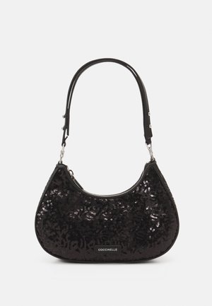 Bolso negro con lentejuelas y forma curva, con una correa corta y cierre de cremallera. Nombre de la marca mostrado en una etiqueta rectangular.