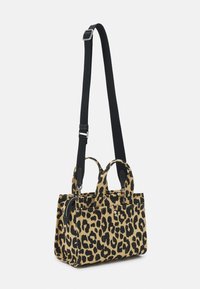 Sac à motif léopard avec poignées supérieures doubles, bandoulière noire amovible, fermeture éclair, forme structurée et tissu texturé.